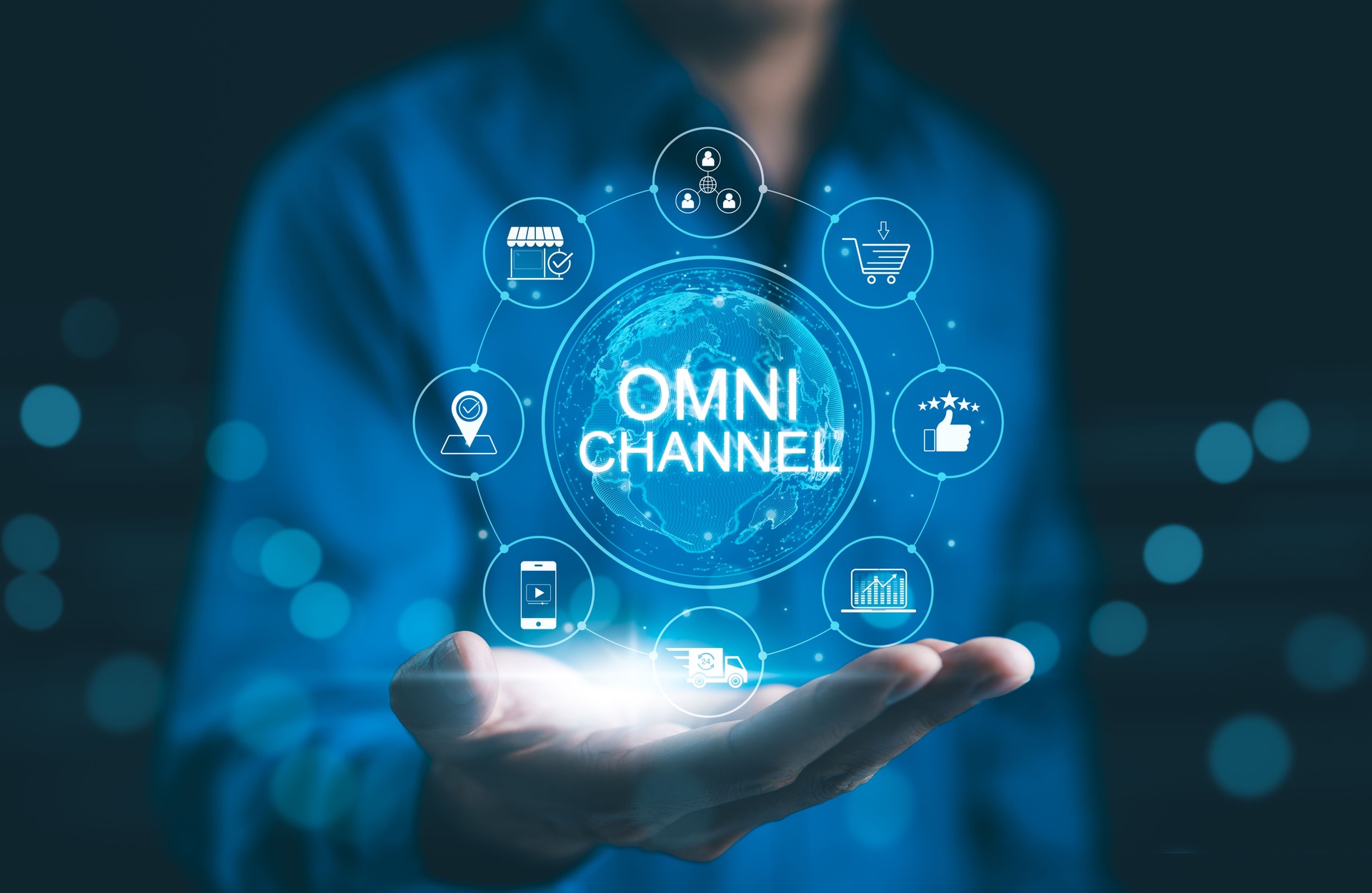 Omni Channel Marketing Concept. Businessman holding digital representation of omni-channel marketing, e-commerce, delivery, social media, analytics, customer engagement, and customer service icons.